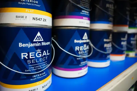 Cans of Benjamin Moore Regal Select interior paint on a shelf