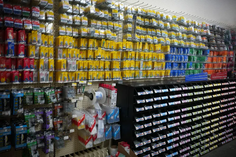 A pegboard wall densely hung with packets of small hardware