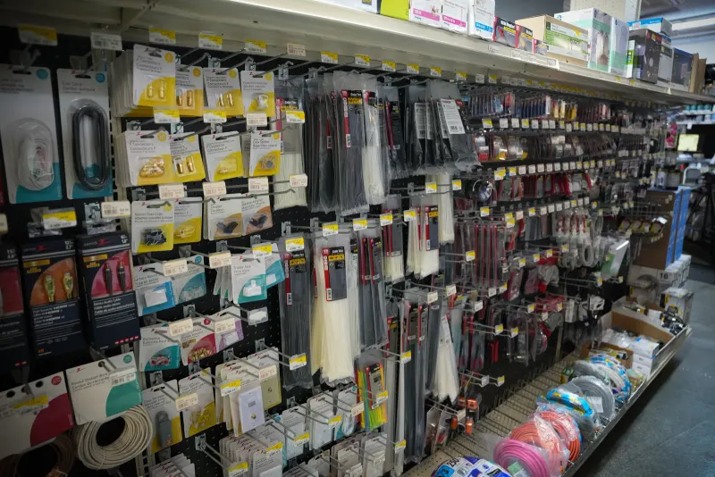 A pegboard of cable ties, packaged fixings and coiled cord