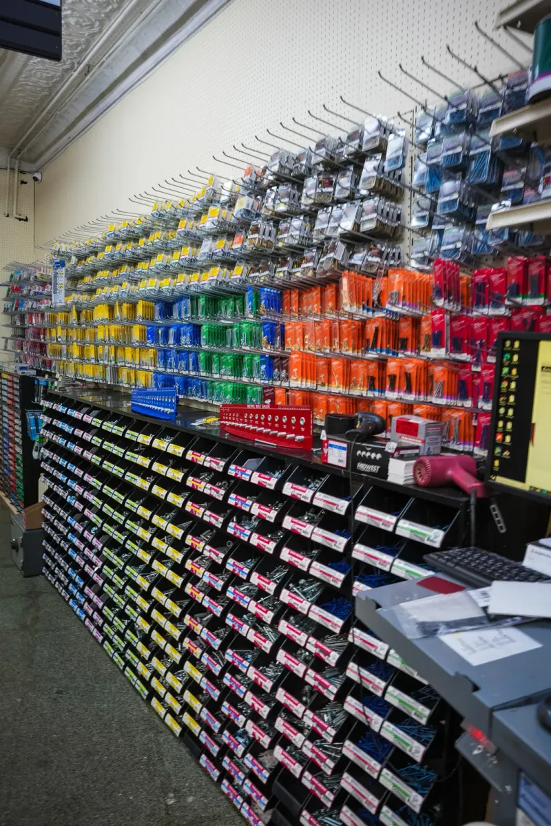 A wall of packaged hardware above rows of small-parts bins