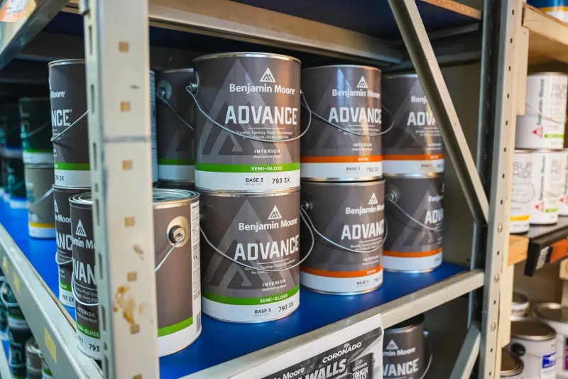 Cans of Benjamin Moore Advance interior paint lined up on a shelf